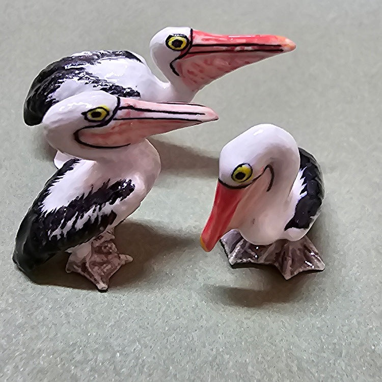 THREE CERAMIC PELICAN FIGURINES