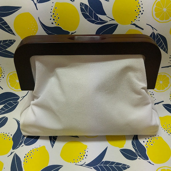 White leather Yellowbird clutch with dark timber handles. Australian made at Spinifex Collections.